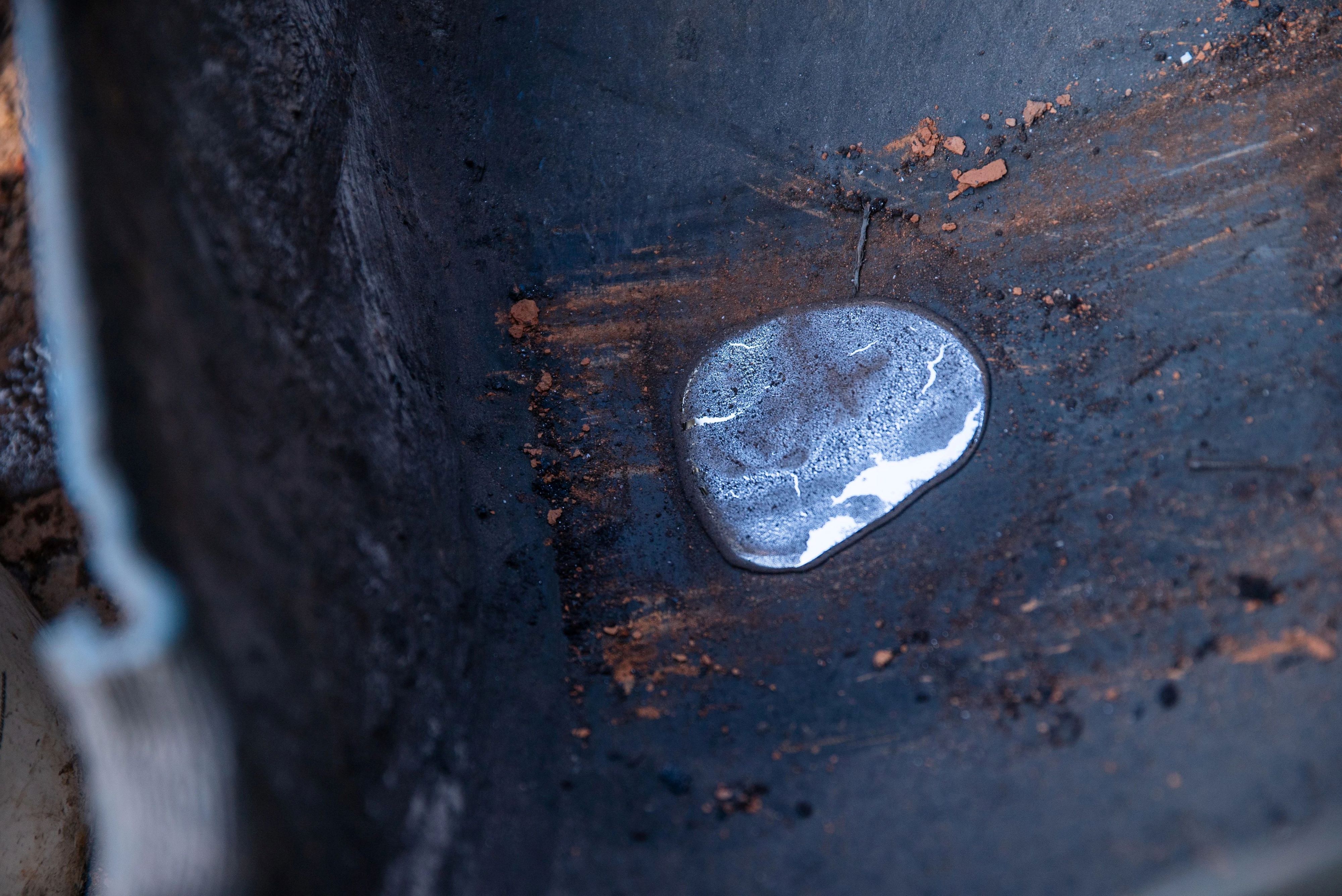 Pure mercury, refined from cinnabar mineral ore, in the bottom of a plastic barrel. Artisanal miners are frequently exposed to the toxic substance and fumes and dust from the refinement process.