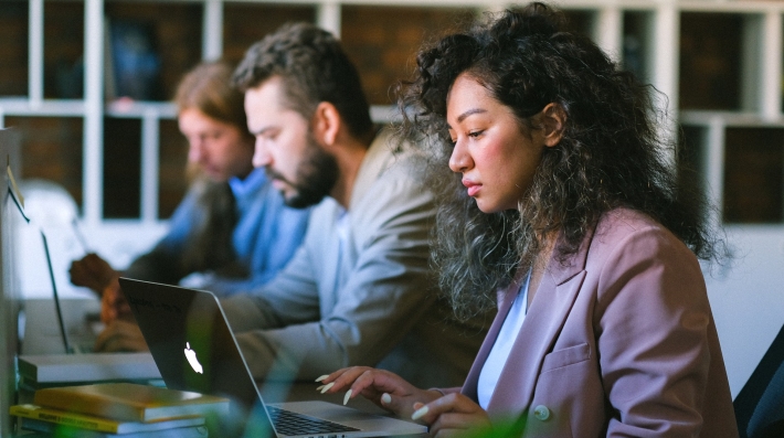 Three young professionals working in an office. 